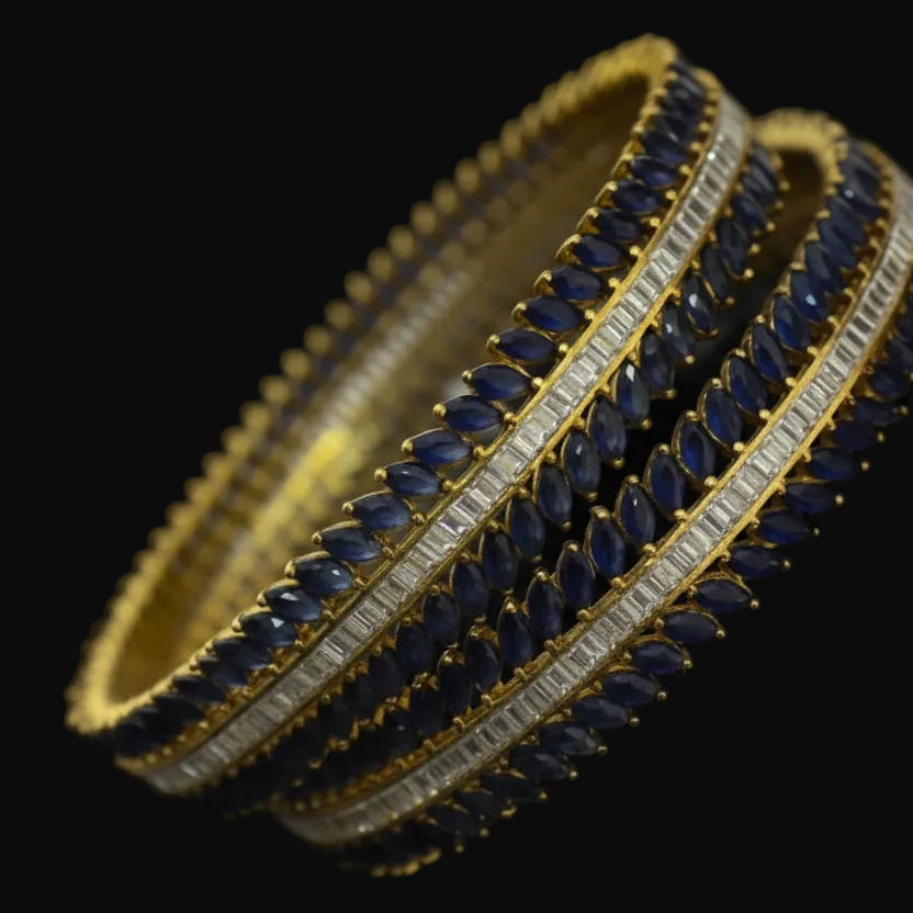 Gold and blue bangles with 'SAHELI' branding on a dark background