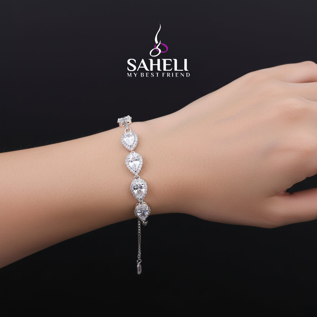 Silver bracelet with clear stones on a black background, featuring the 'Saheli' brand.