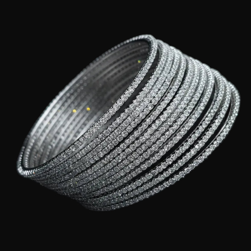 Set of silver bangles on a black cushion with 'SAHELI' branding.