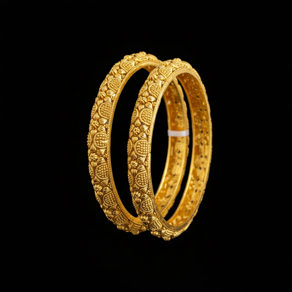 Gold bangles with intricate designs on a gray background, featuring the brand 'SAHELI'.