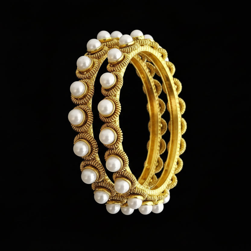 Gold and pearl bangles on a gray stand with 'SAHELI' branding.