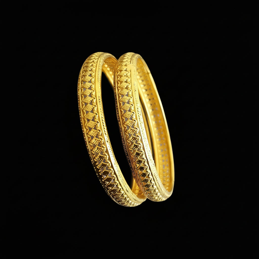 Gold bangles with intricate designs on a gray background, featuring the brand 'Saheli'.