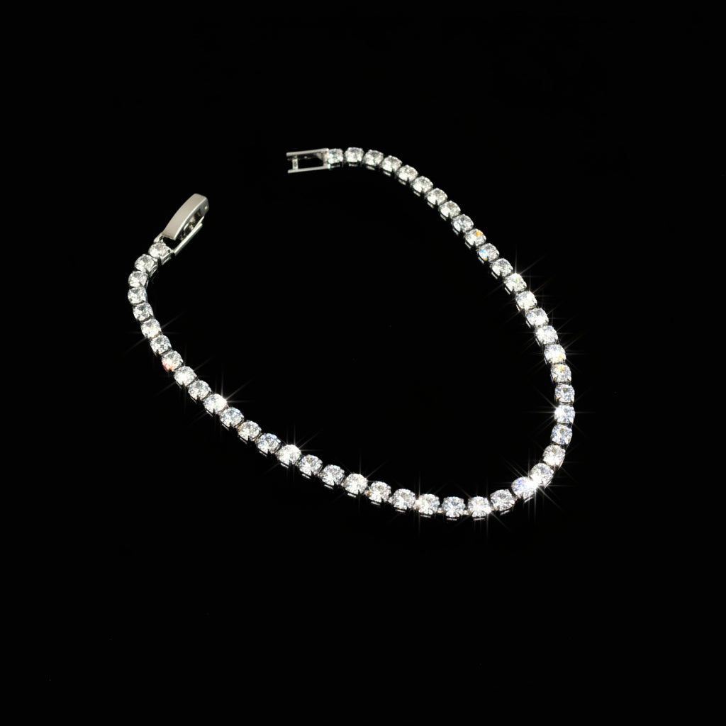 Silver bracelet with clear stones on a black background