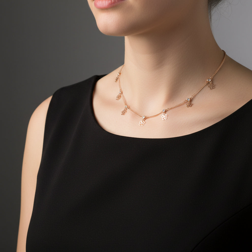 Rose gold bracelet with flower charms on a branded card against a black background
