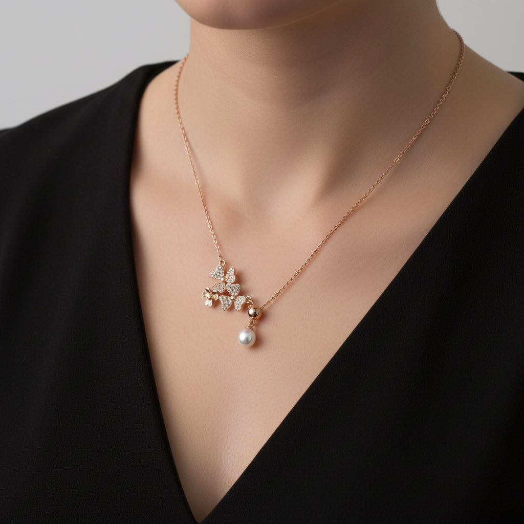 Rose gold necklace with a pearl pendant on a branded card against a black background