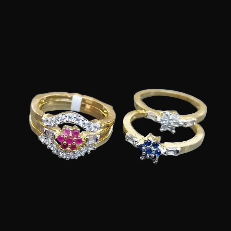 Two gold rings with gemstones on a gray background, featuring the brand 'SAHELI'.