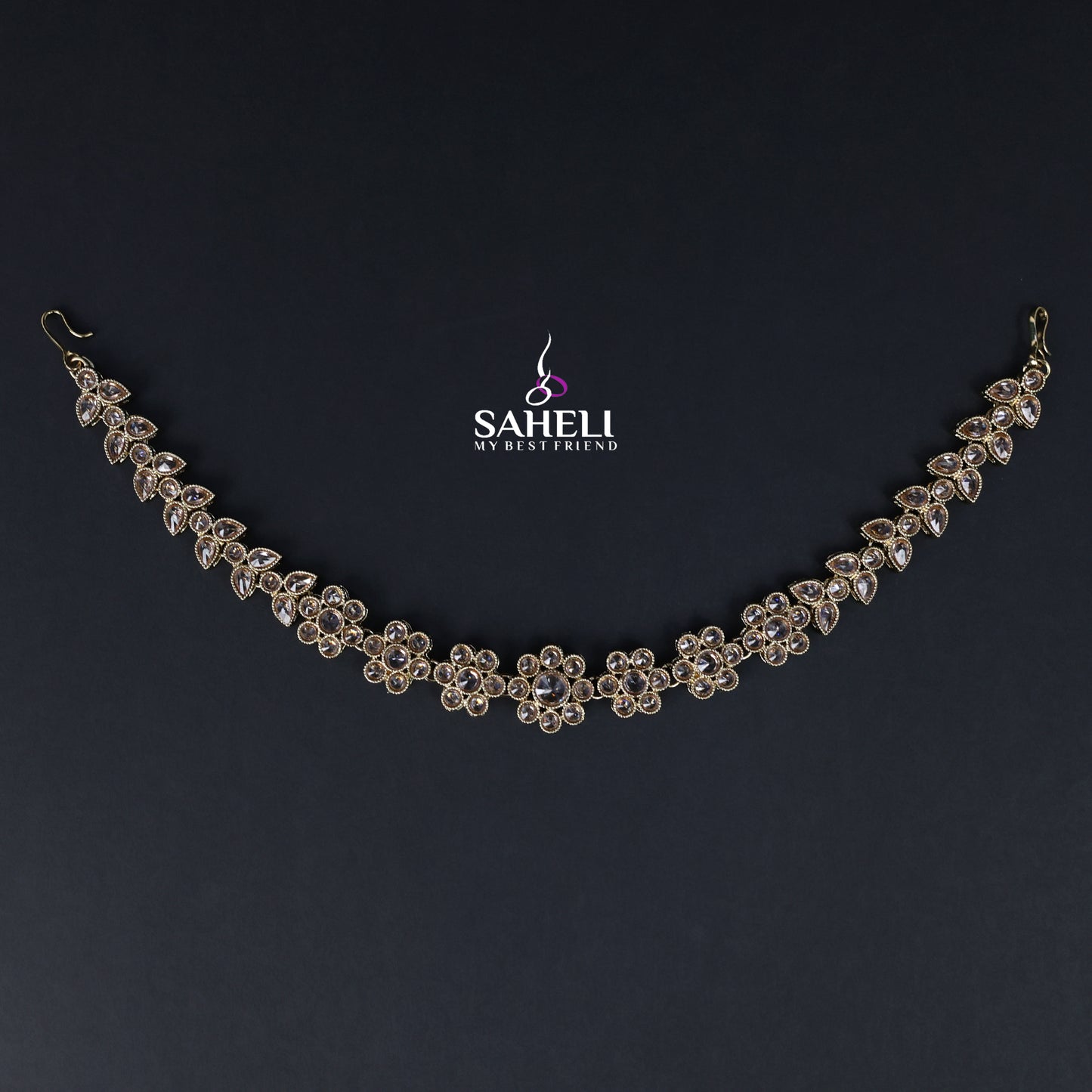 Delicate silver necklace on a dark background with 'SAHELI' branding.