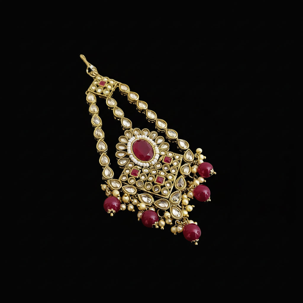 Ornate gold and red gemstone necklace on a dark background with 'SAHELLI' branding.