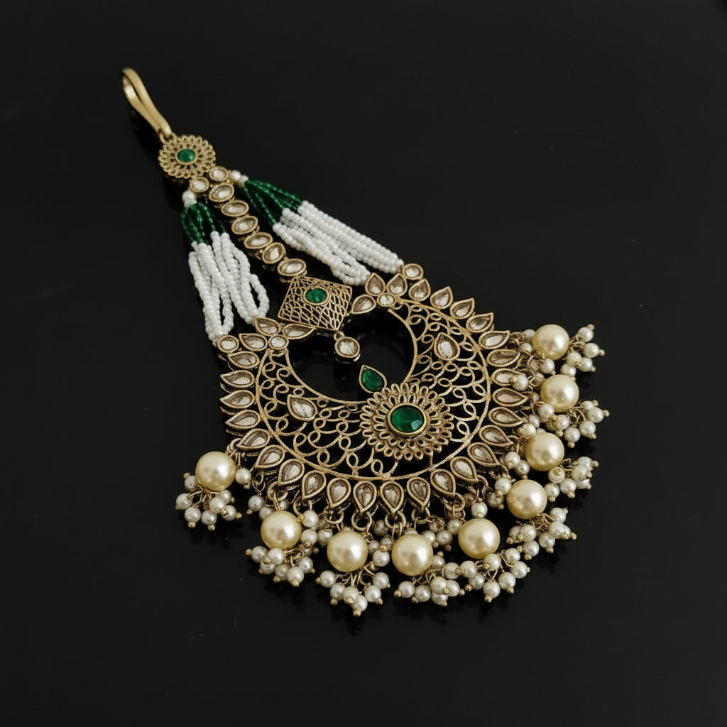 Decorative pendant with pearls and green stones on a black background