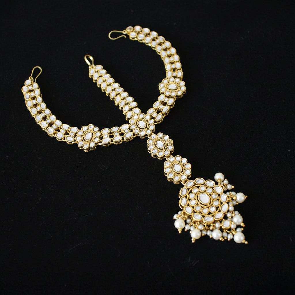 Gold and pearl necklace on a dark background with 'SAHELI' branding.