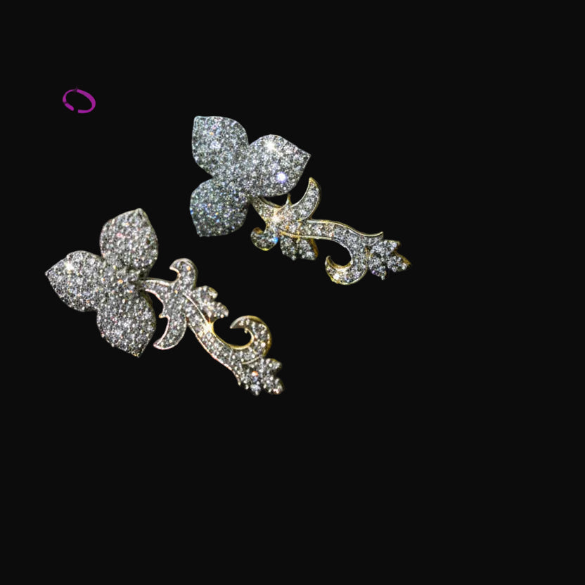 Pair of silver butterfly earrings with clear gemstones on a dark background, featuring the brand 'Saheli'.