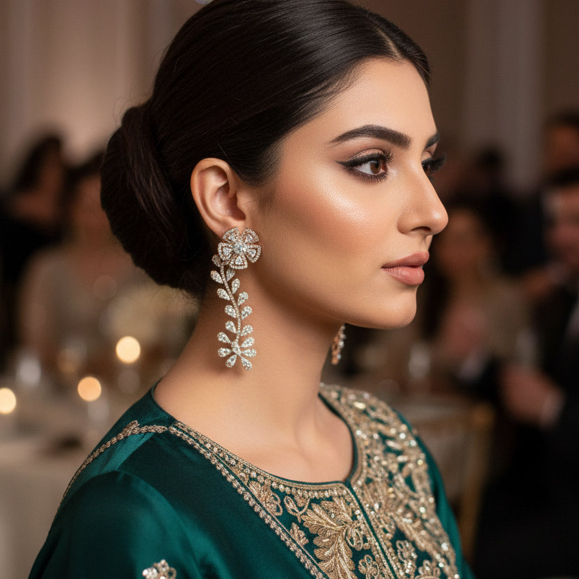 Pair of floral diamond earrings on a dark background with 'SAHELI' branding.