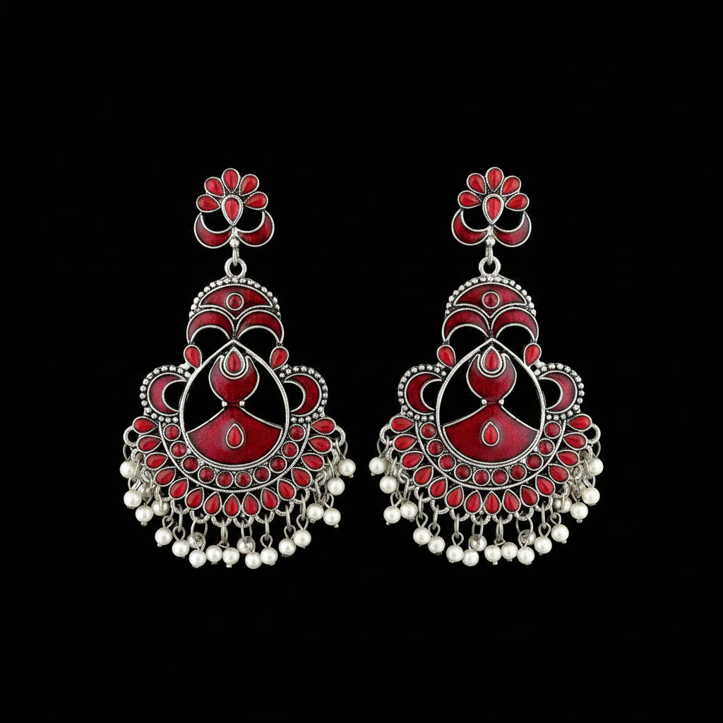 Ornate earrings with red and white details on a gray background, featuring the brand 'SAHELI'.