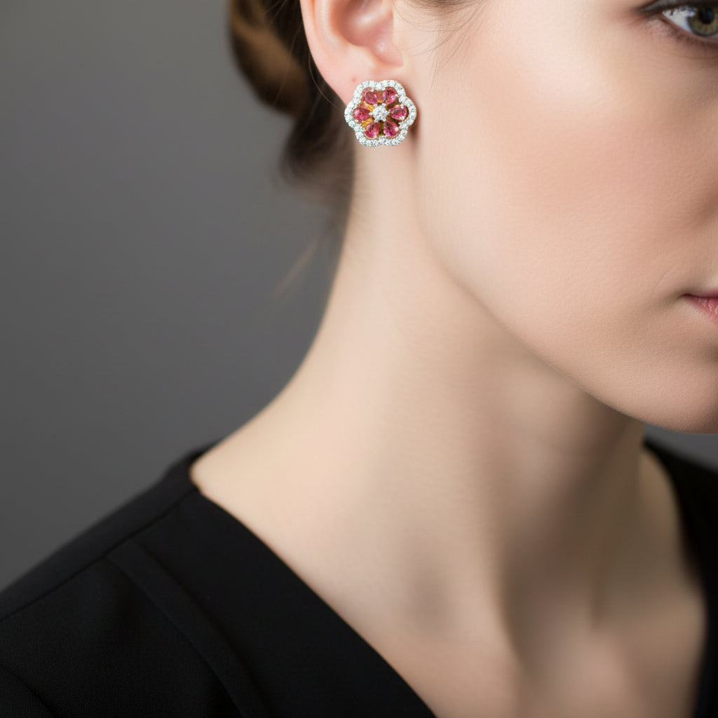 Flower-shaped earrings with colorful gemstones on a gray surface