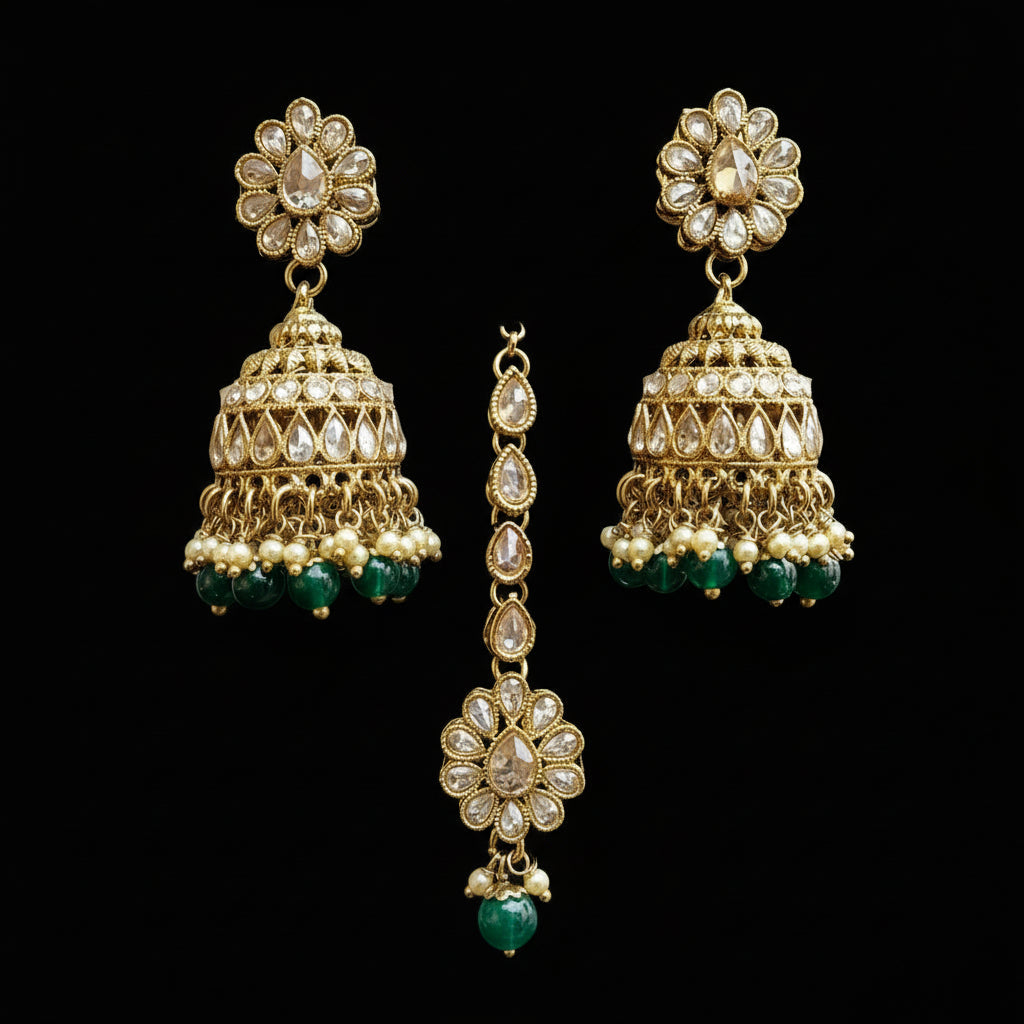 Gold and green earrings on a gray stand with 'Saheli' branding.