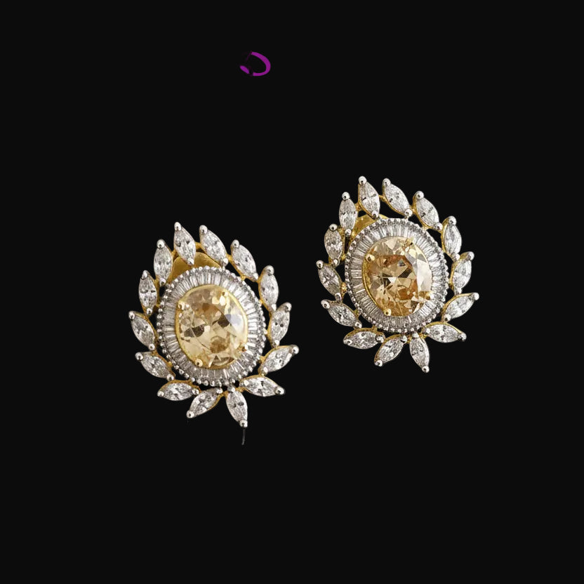 Gold and diamond earrings on a dark background with 'Saheli' brand logo.