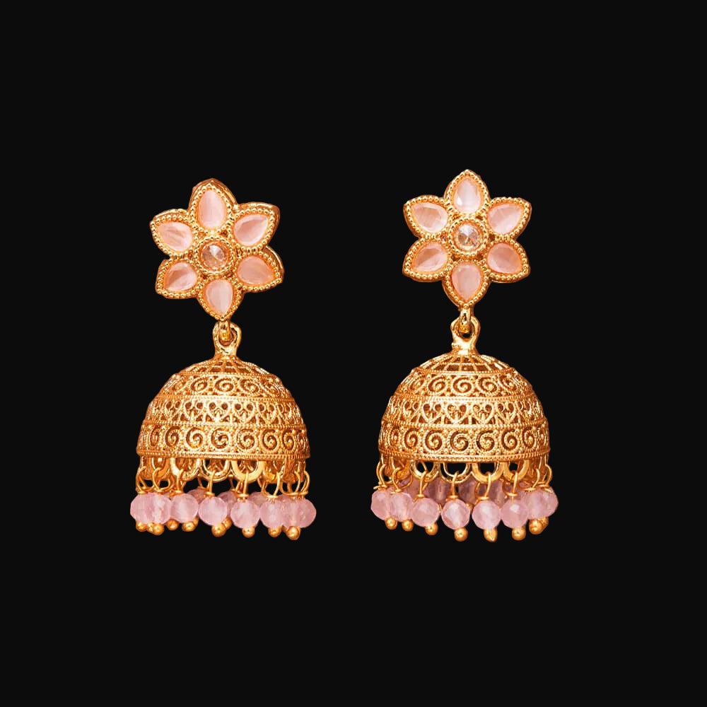 Gold earrings with floral top and beaded bottom on a brown fabric background