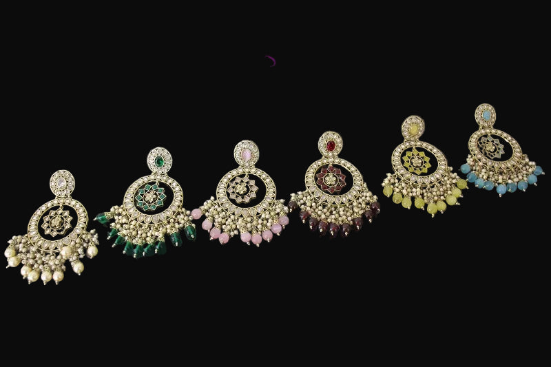 Set of five ornate earrings with colorful stones on a gray background, featuring the brand 'Saheli'.