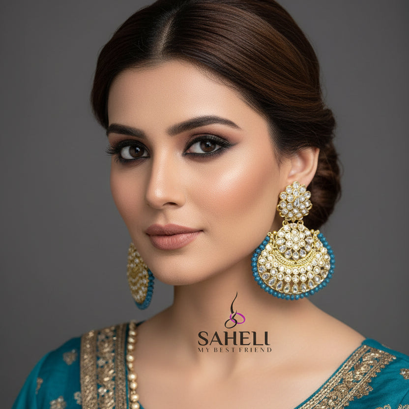 Gold and blue earrings with 'SAHELI' branding on a gray background
