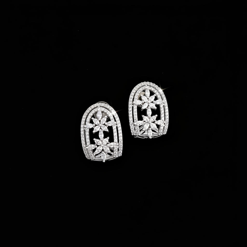 Silver earrings with intricate design on a dark background, featuring the brand 'Saheli'.