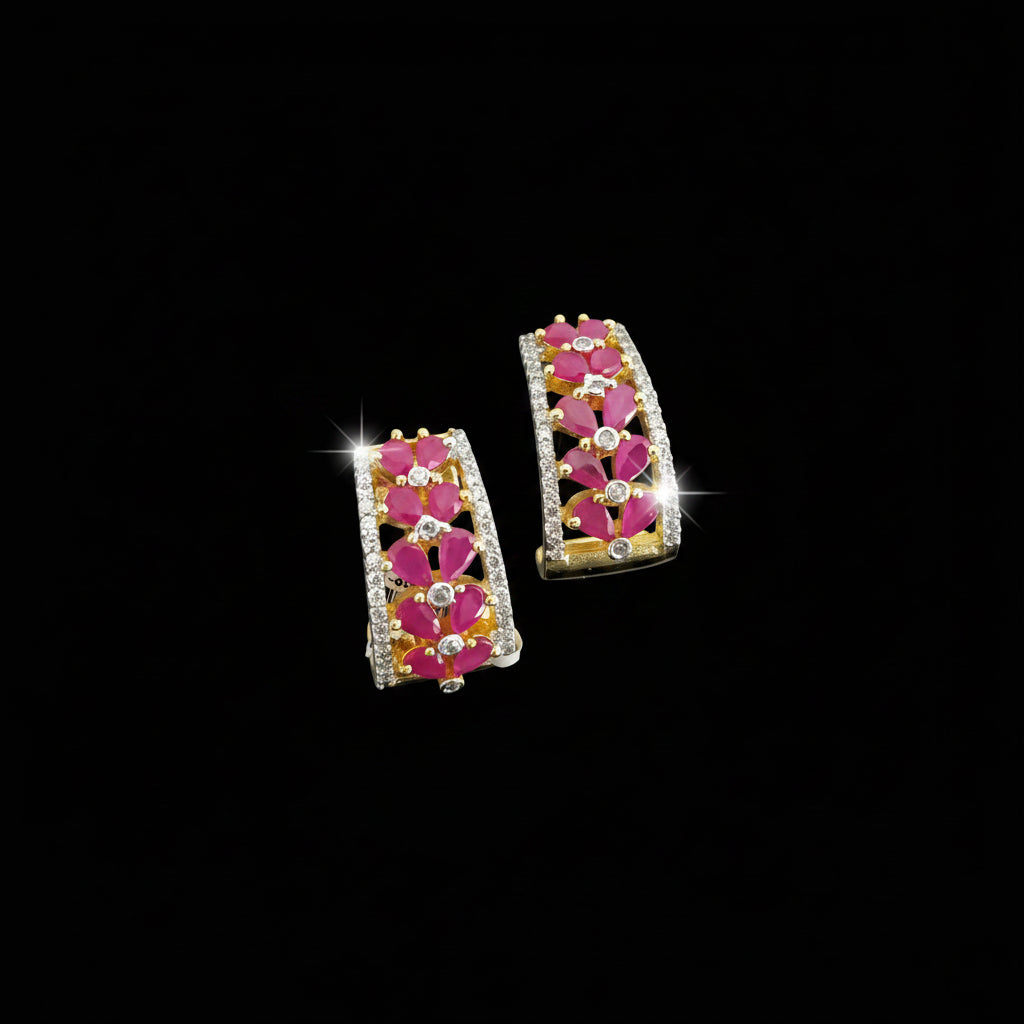Pair of earrings with pink floral design on a gray background, featuring the brand 'Saheli'.