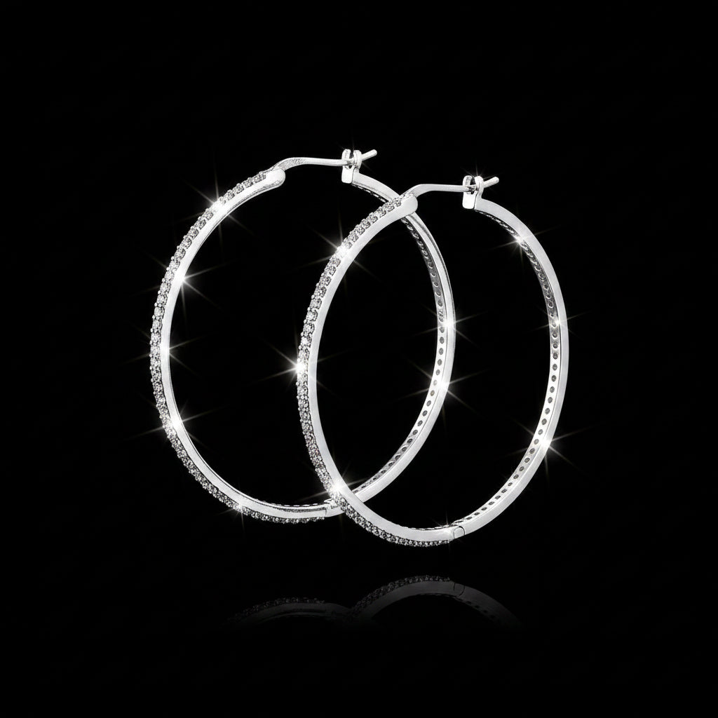 Silver hoop earrings on a gray background with 'Saheli' branding.