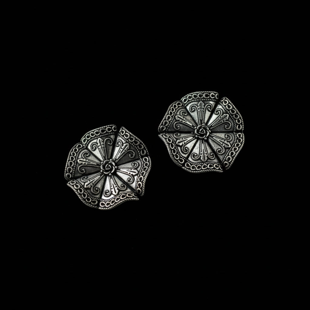 Pair of silver decorative earrings on a dark gray background
