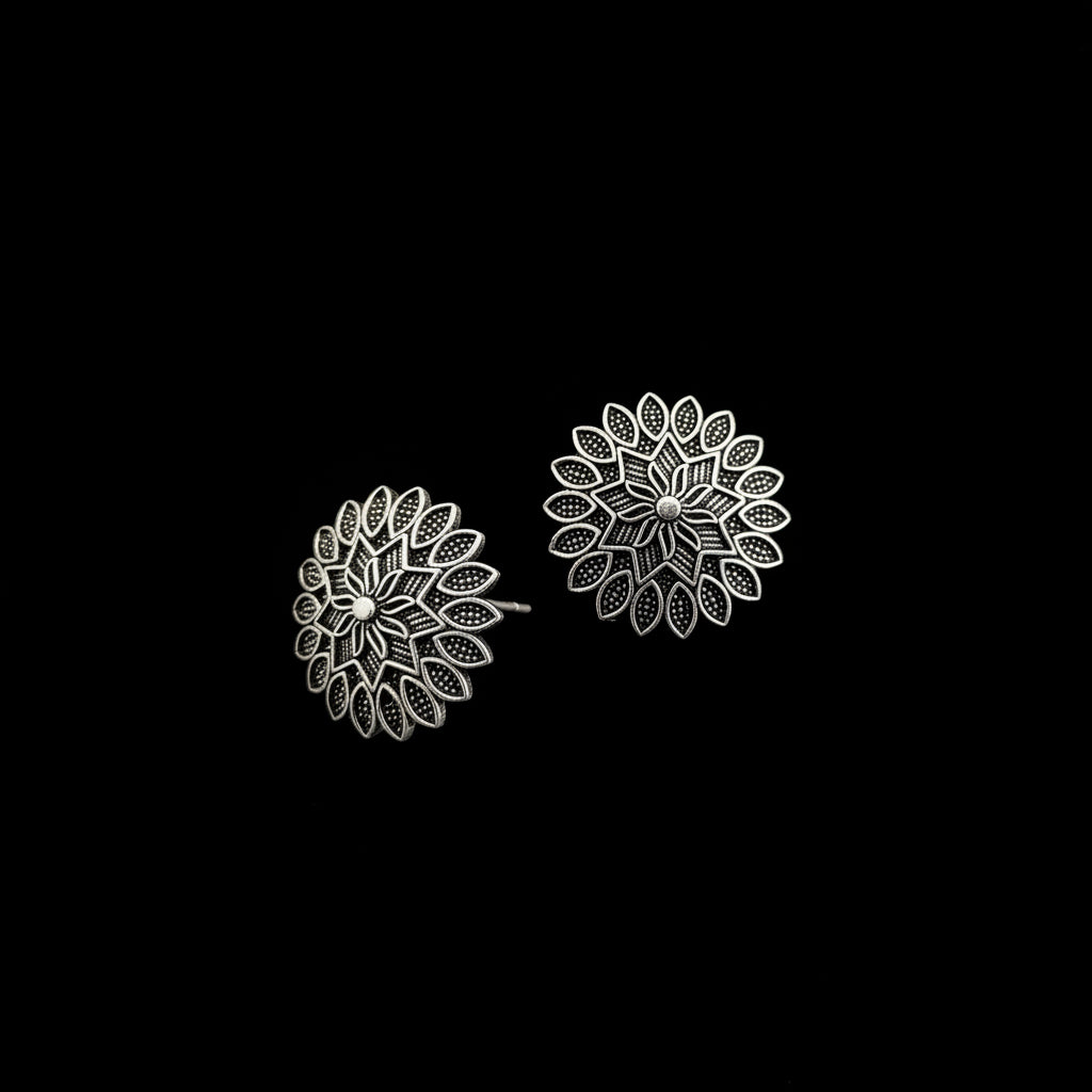 Pair of silver floral earrings on a gray background