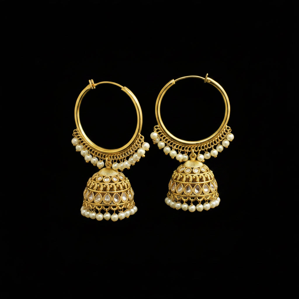 Gold hoop earrings with pearl drops on black earring stands against a gray background.