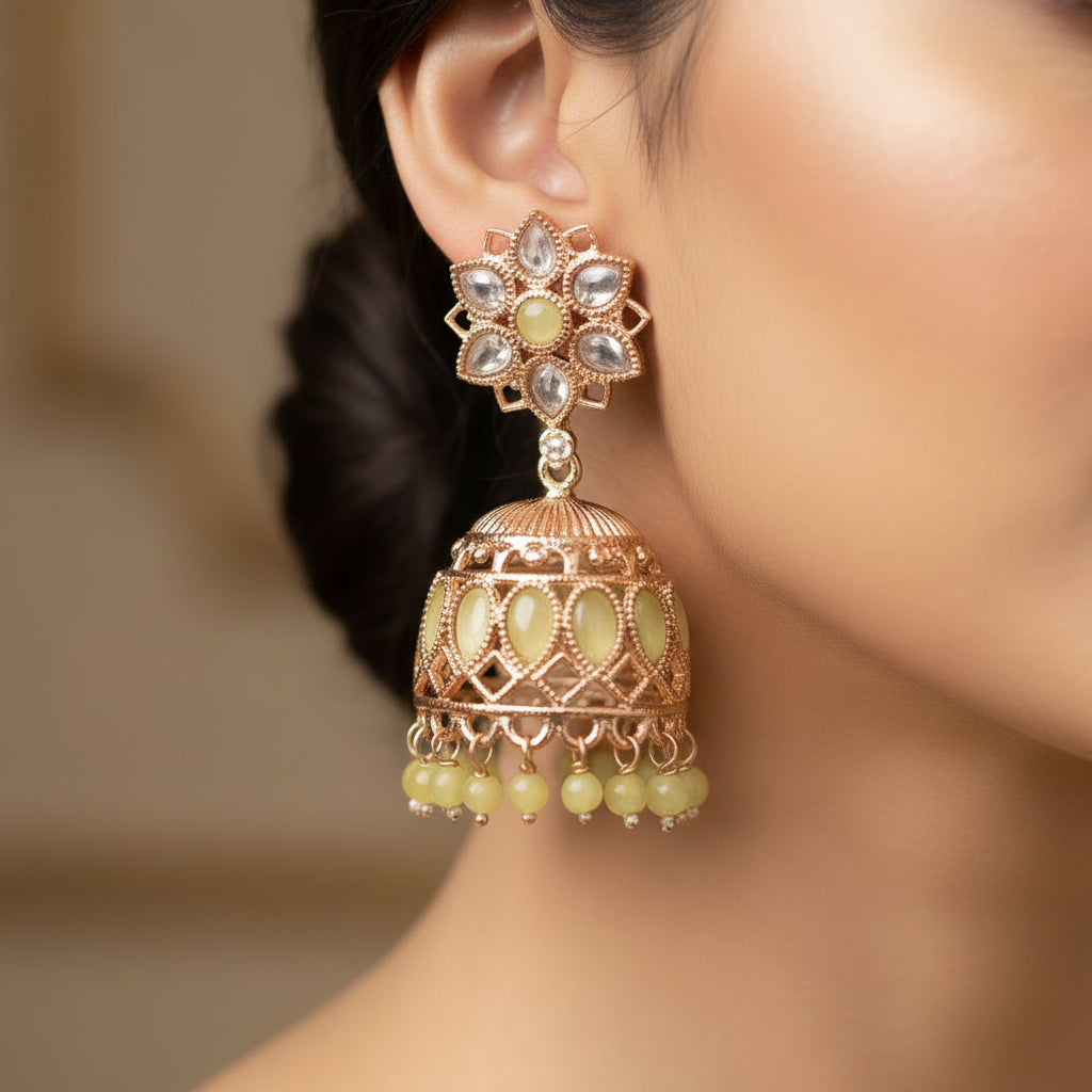 Gold and green floral earrings on a black background