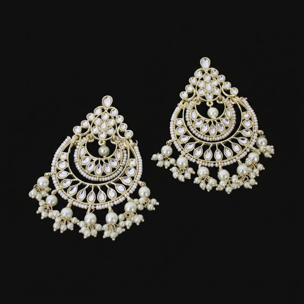 Ornate gold and pearl earrings on a dark background