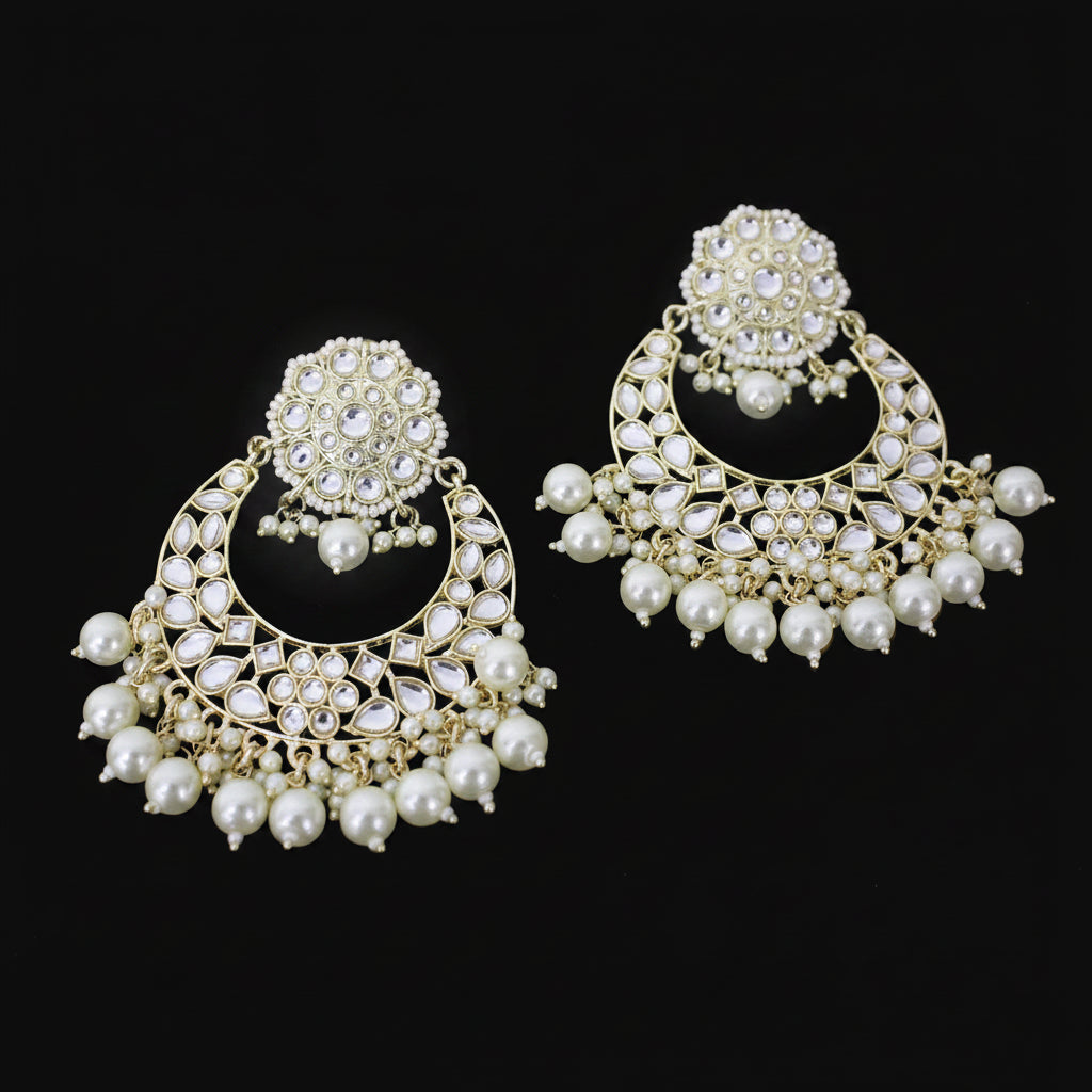 Pair of ornate earrings with pearls on a dark background