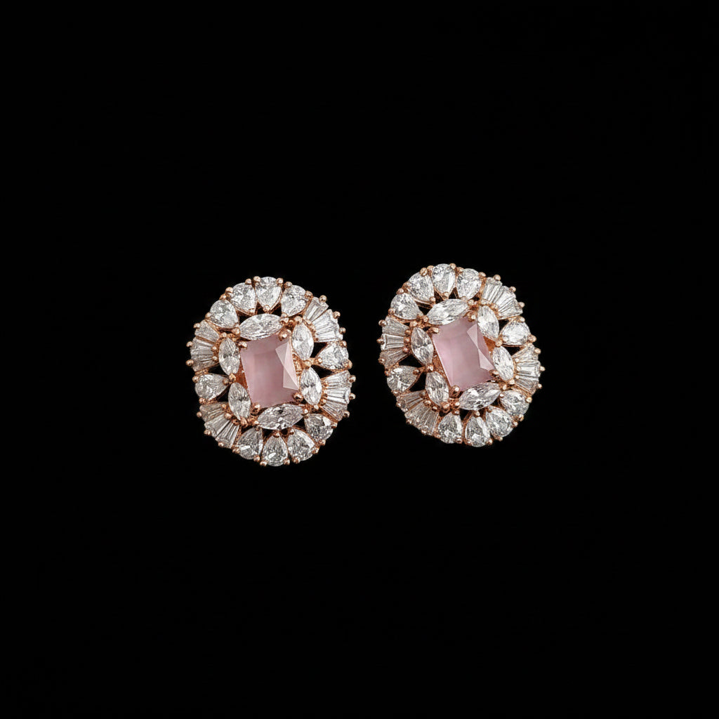 Pair of earrings with pink gemstones and rose gold accents on a dark background with 'Saheli' branding.
