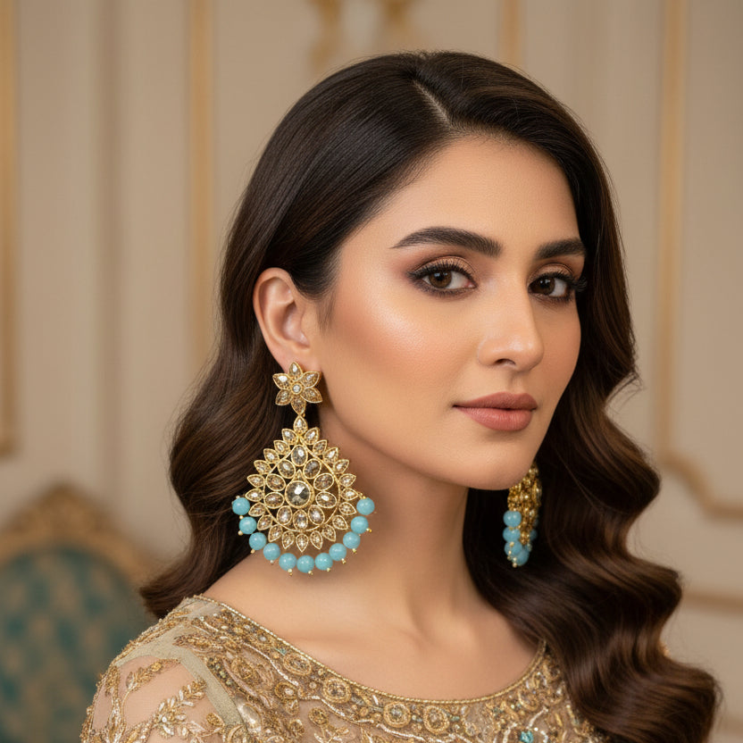 Pair of gold and turquoise earrings on a dark background