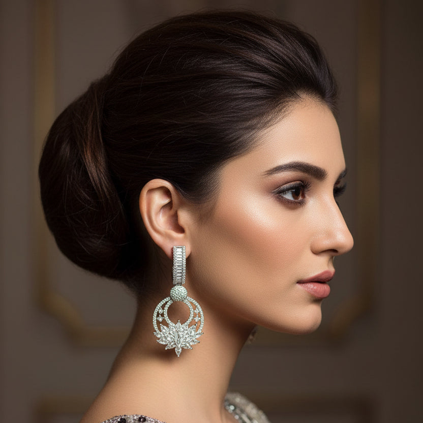 Pair of silver earrings with diamond accents on a dark gray background