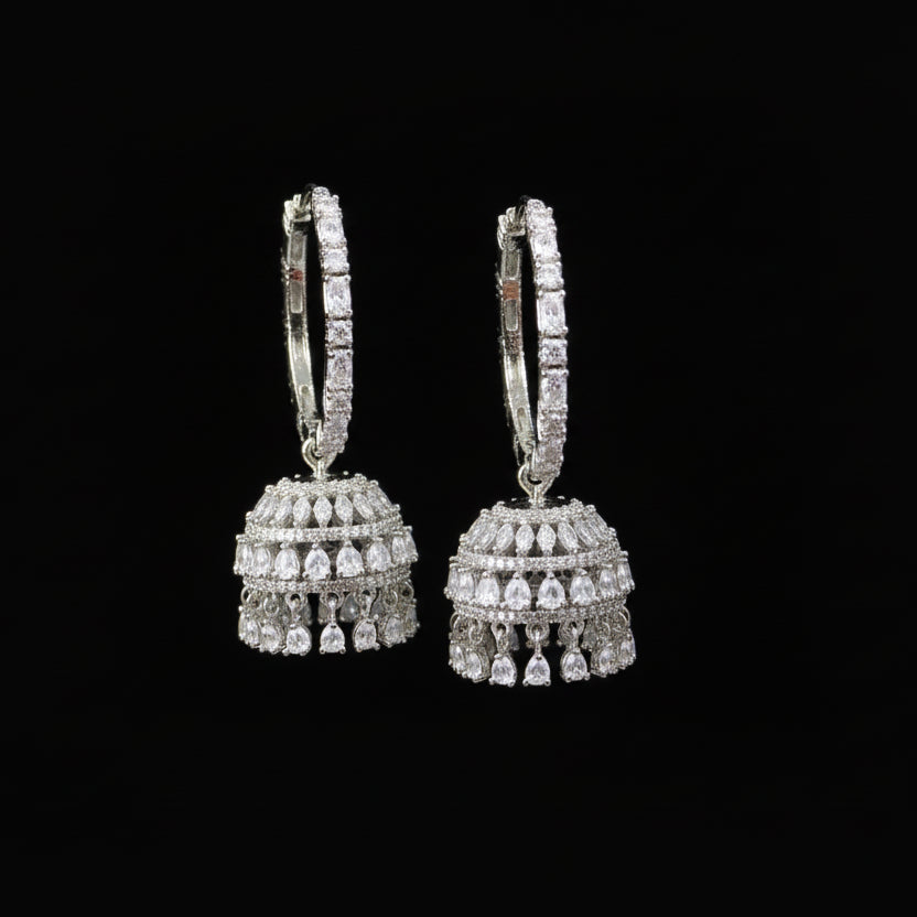 Jewelry store setting with a hand holding a pair of earrings.
