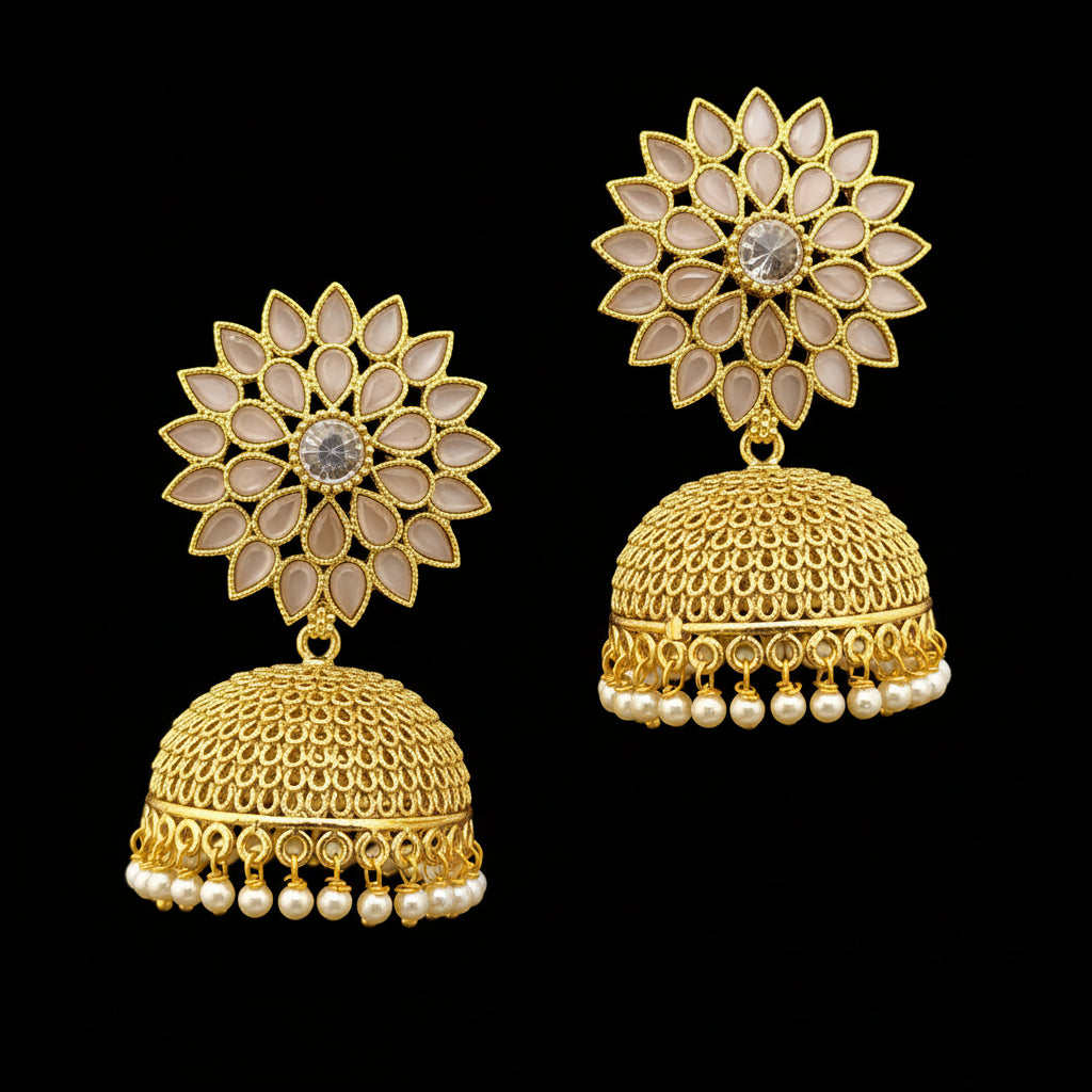 Gold earrings with floral design on a gray stand, branded 'Saheli'.