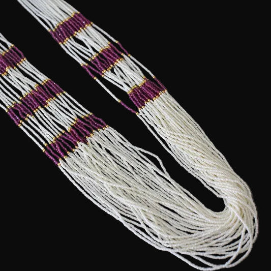 White beaded belt with purple and gold accents on a dark background