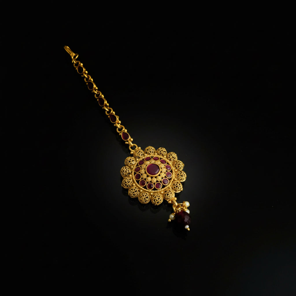Gold necklace with red gemstones on a black background