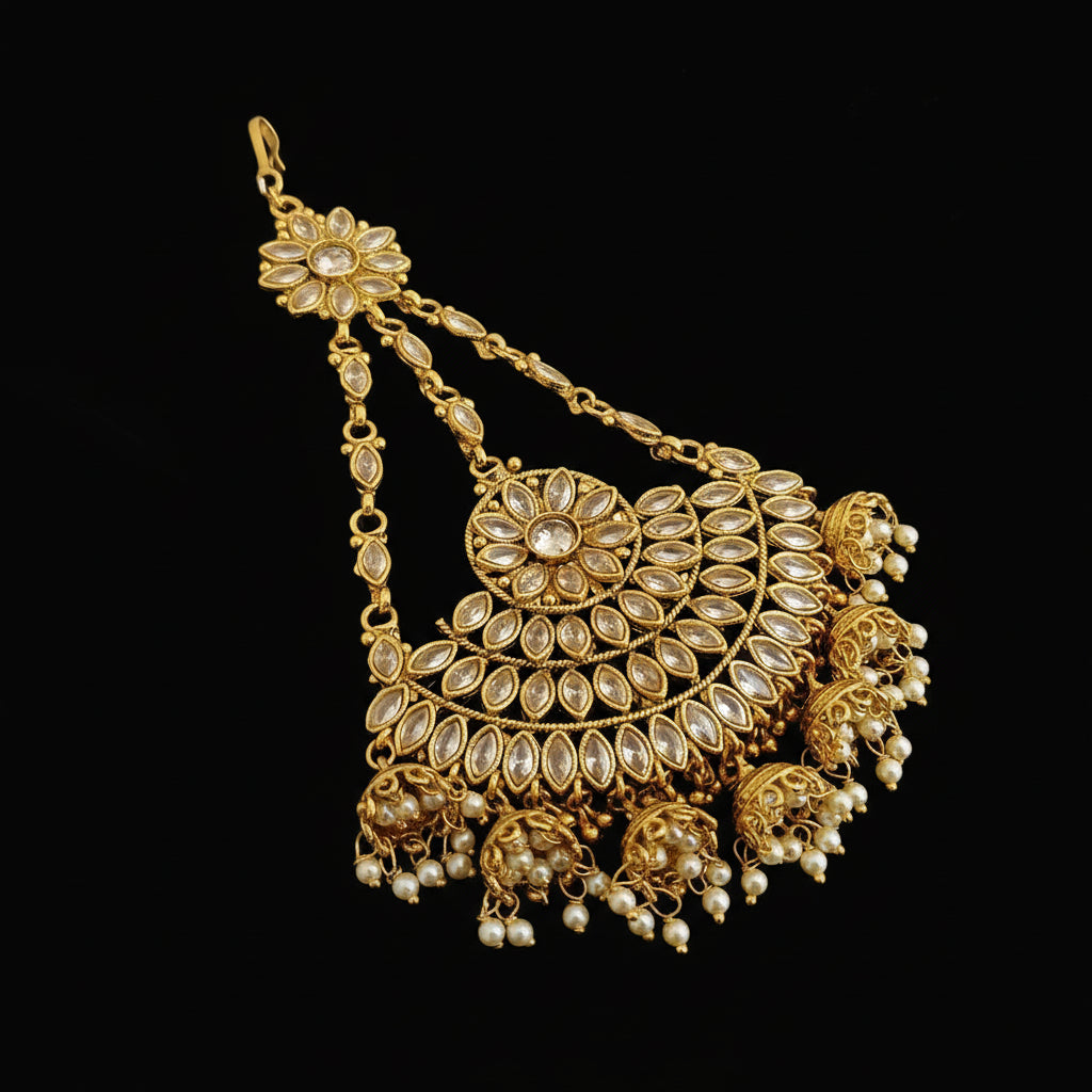 Gold necklace with floral designs on a dark background, featuring the brand 'SAHELI'.