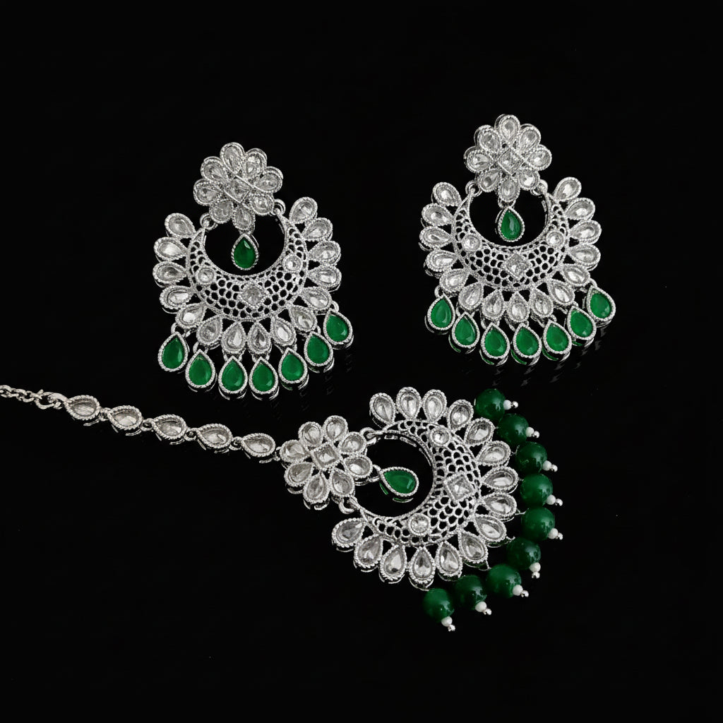 Jewelry set with green stones on a dark background, featuring the brand 'Saheili'.