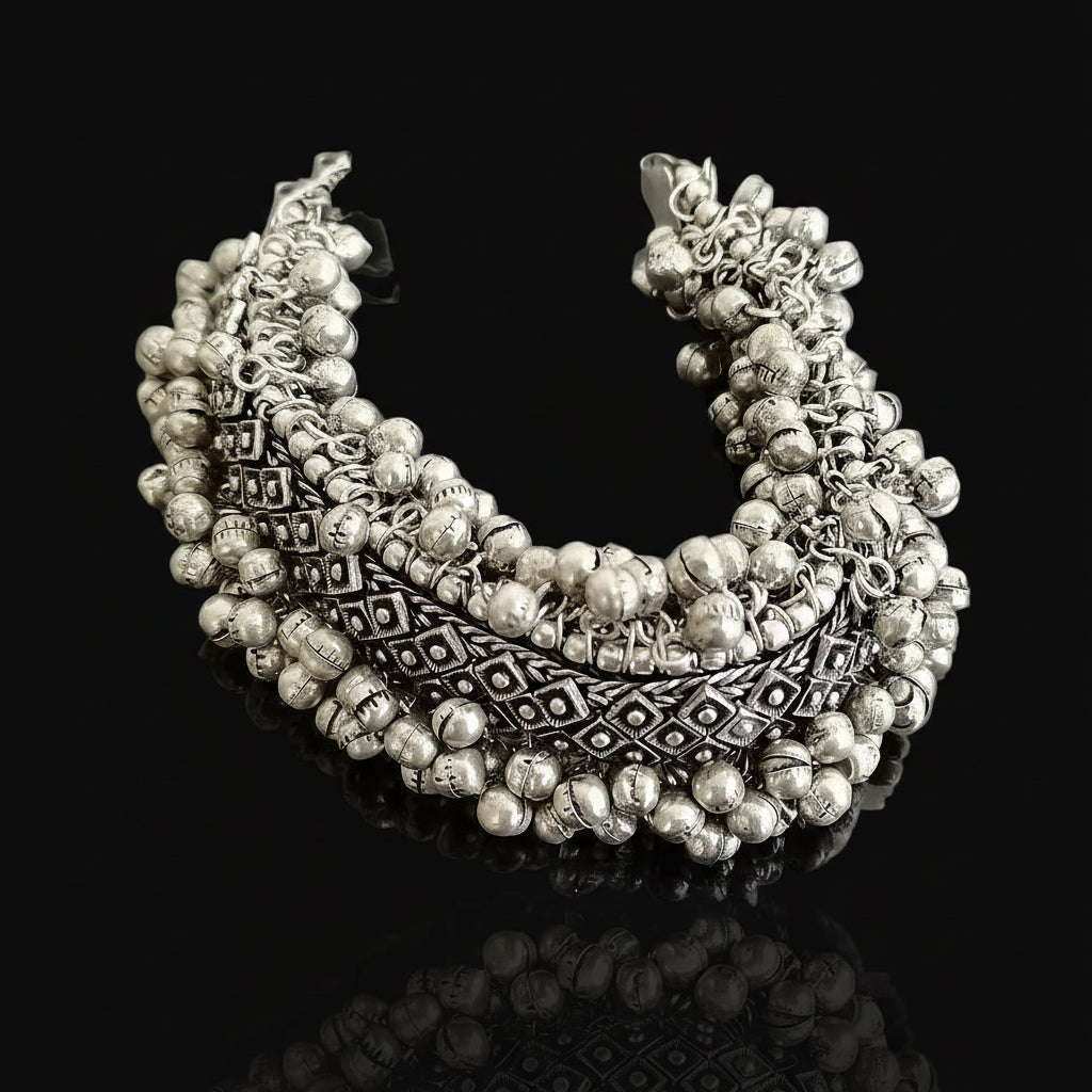 Silver beaded necklace with intricate designs on a gray background, branded 'Saheli'.