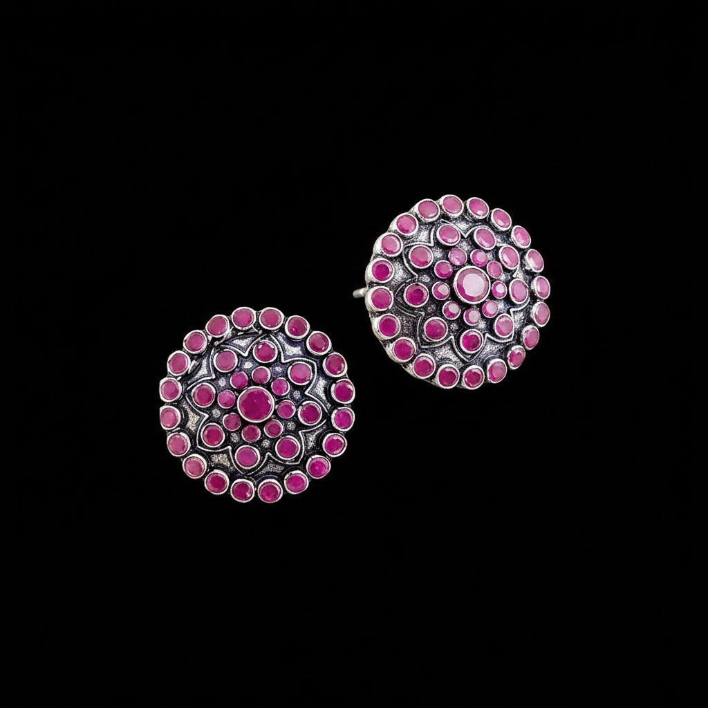 Pair of pink and silver earrings on a gray background with 'Saheli' branding.