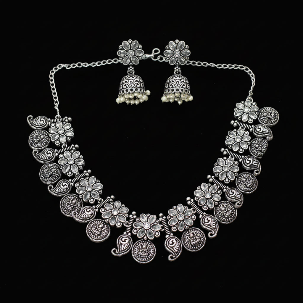 Silver necklace and earrings set on a gray background