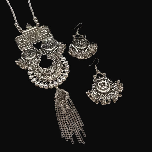Silver jewelry set with necklace and earrings on a white background, featuring the brand 'Saheli'.