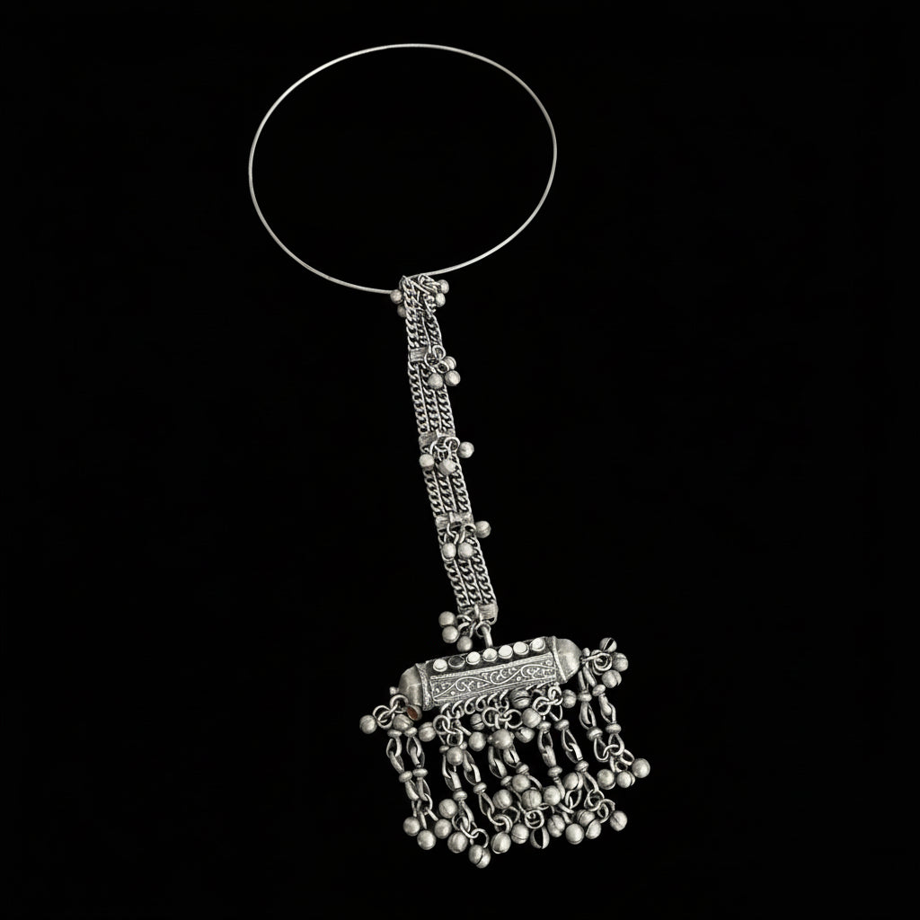 Silver bangle with decorative elements on a gray background, featuring the brand 'Saheli'.