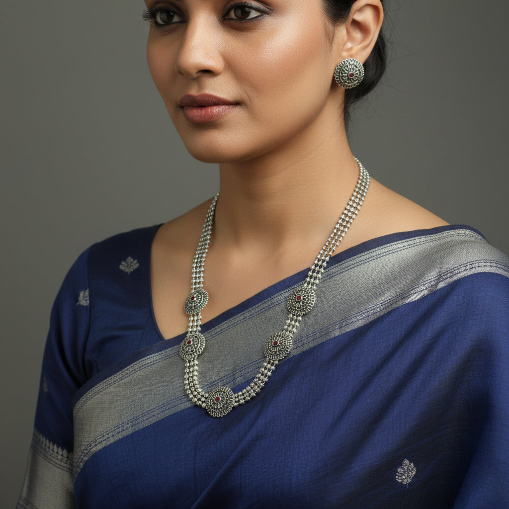 Silver necklace and earrings set on a black background