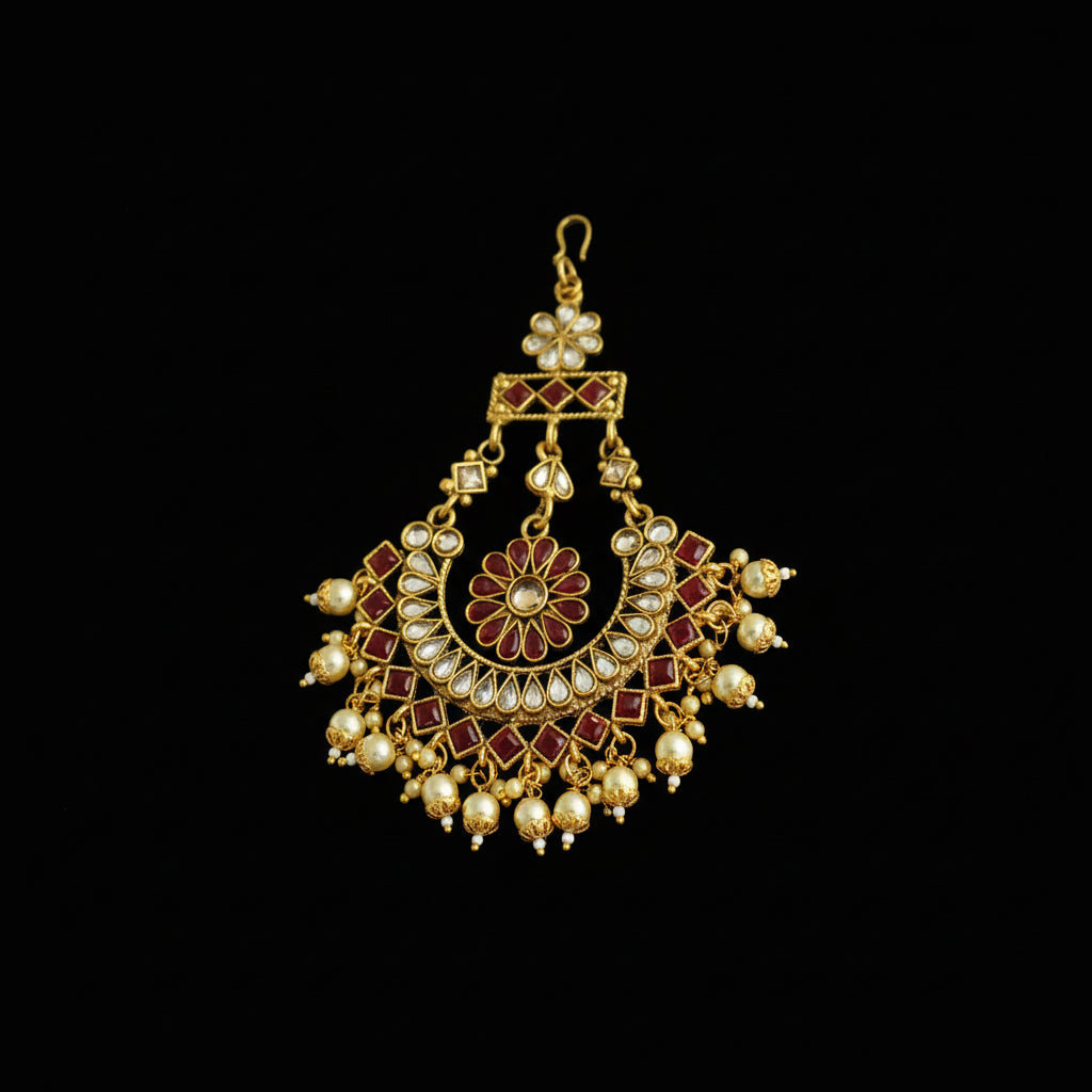 Ornate gold and red pendant on a dark background
