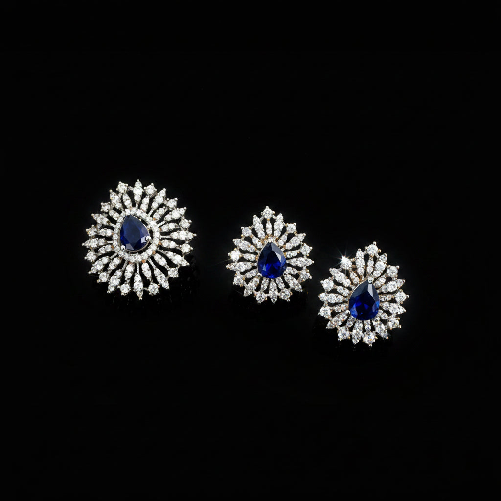 Set of diamond earrings with blue gemstones on a gray background, featuring the brand 'Saheli'.