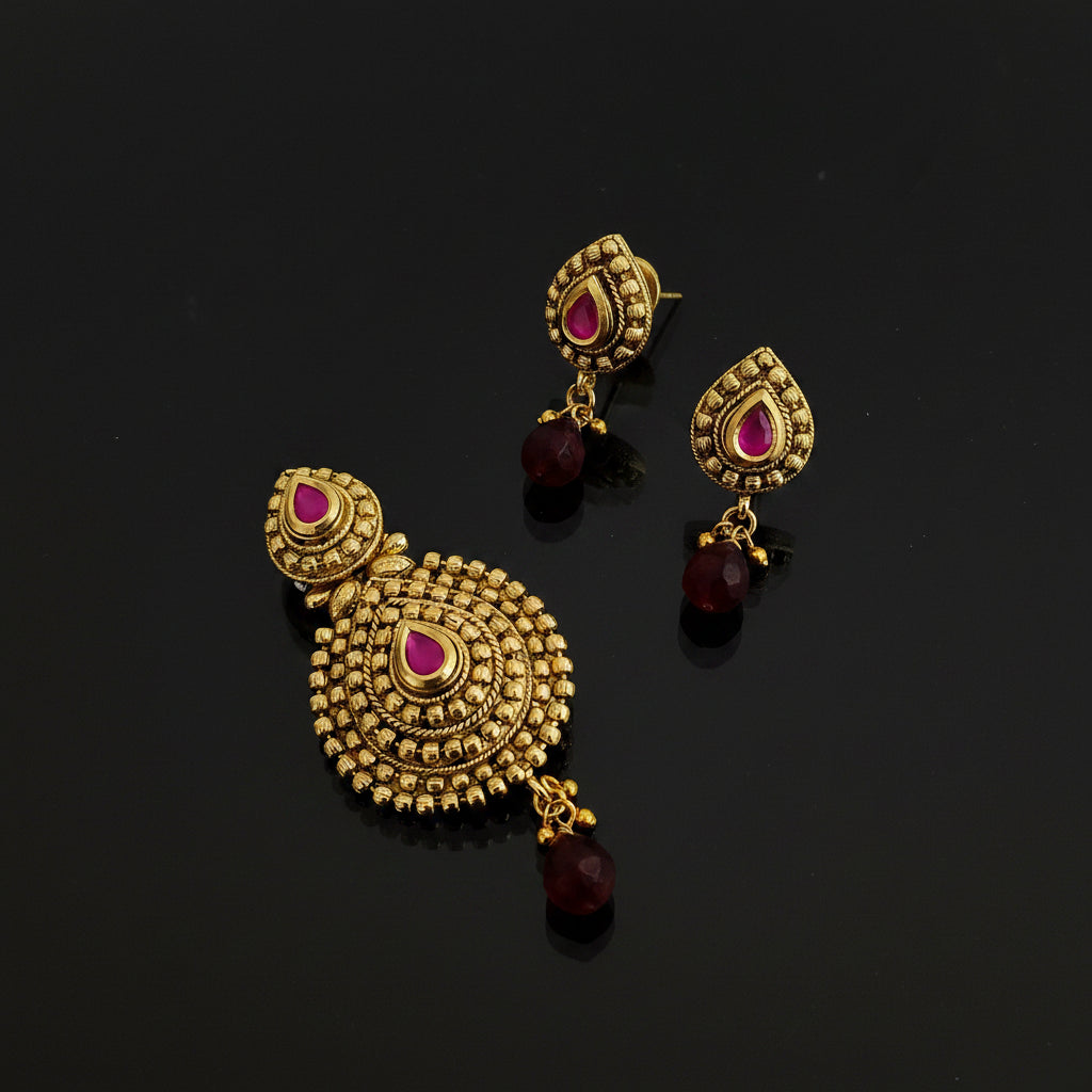 Gold earrings with pink gemstones on a black stand, branded 'SAHELI'.